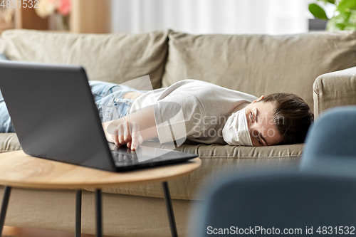 Image of sick bored woman with laptop lying on sofa at home