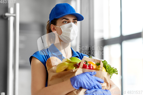 Image of delivery woman in face mask with food in paper bag