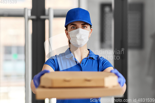 Image of delivery woman in face mask with pizza boxes