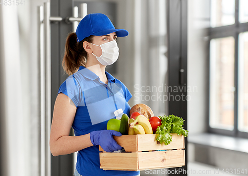 Image of delivery woman in face mask with food in box