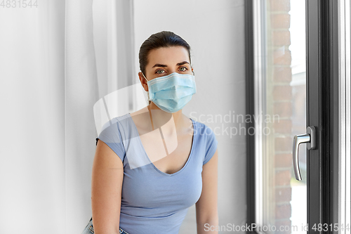 Image of sick young woman wearing protective medical mask