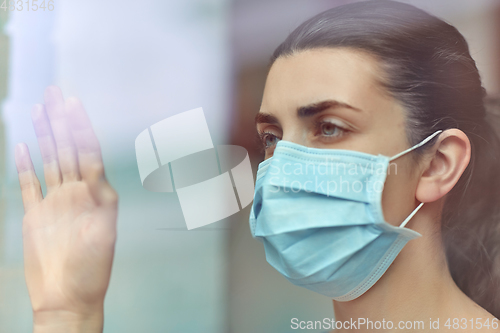 Image of sick young woman wearing protective medical mask