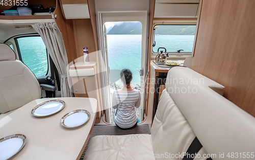 Image of Woman in the interior of a camper RV motorhome with a cup of cof