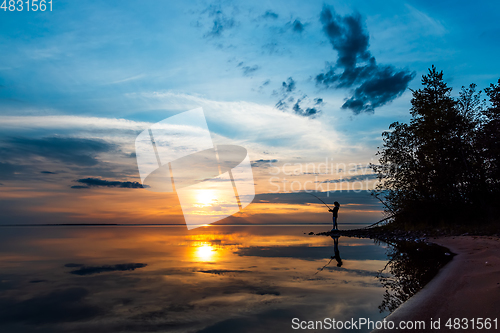 Image of Woman fishing on Fishing rod spinning in Finland at sunset.