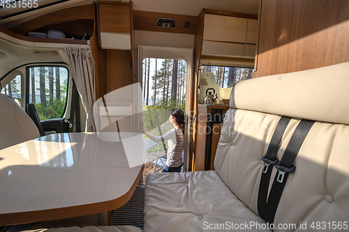 Image of Woman in the interior of a camper RV motorhome with a cup of cof