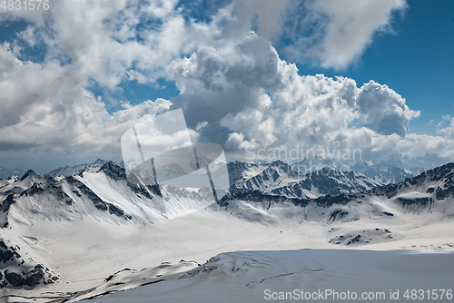 Image of Mountain clouds over beautiful snow-capped peaks of mountains an