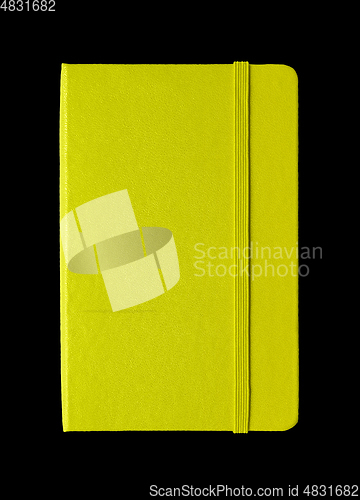 Image of Lime green closed notebook isolated on black