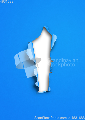 Image of Blue torn paper with hole