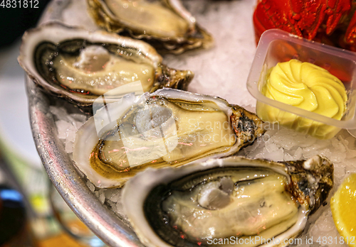 Image of Close-up of oysters with sauce on ice in a restaurant