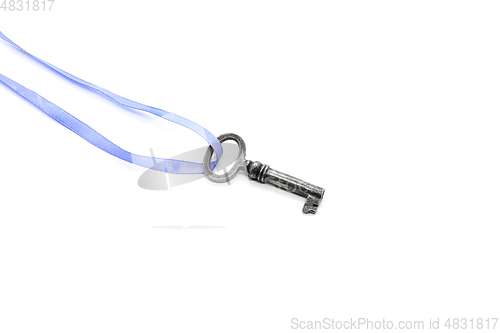 Image of Vintage silver key on blue ribbon on white background