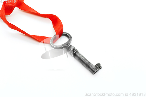 Image of Vintage silver key with red ribbon on white background