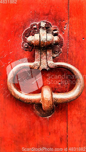 Image of Vintage bright red wooden door with metallic doorhandle