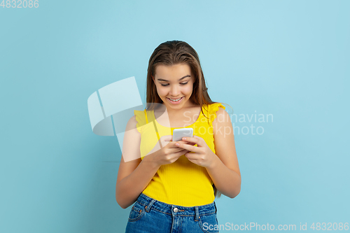 Image of Caucasian teen girl portrait isolated on blue studio background