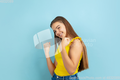 Image of Caucasian teen girl portrait isolated on blue studio background