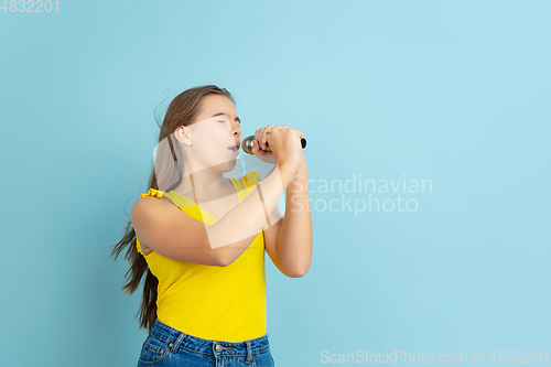 Image of Caucasian teen girl portrait isolated on blue studio background