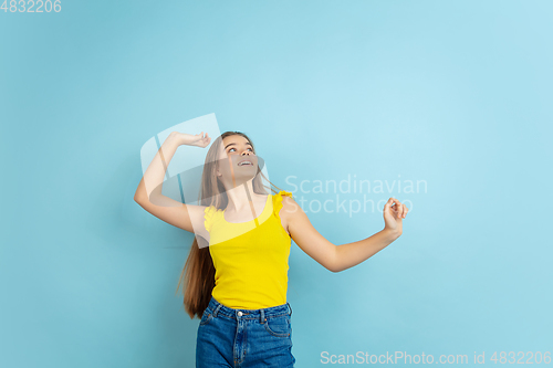 Image of Caucasian teen girl portrait isolated on blue studio background