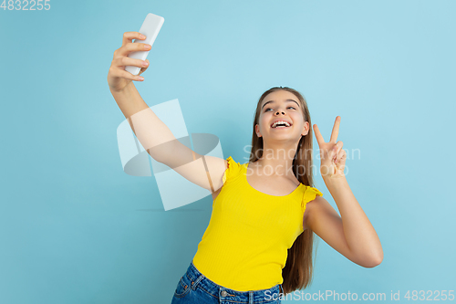 Image of Caucasian teen girl portrait isolated on blue studio background
