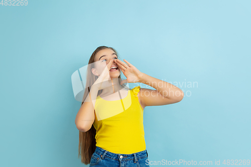 Image of Caucasian teen girl portrait isolated on blue studio background