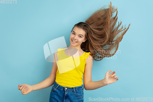 Image of Caucasian teen girl portrait isolated on blue studio background