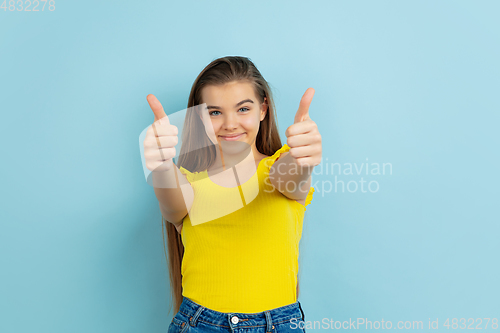 Image of Caucasian teen girl portrait isolated on blue studio background