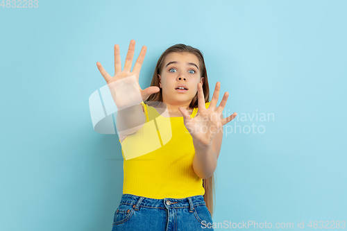 Image of Caucasian teen girl portrait isolated on blue studio background