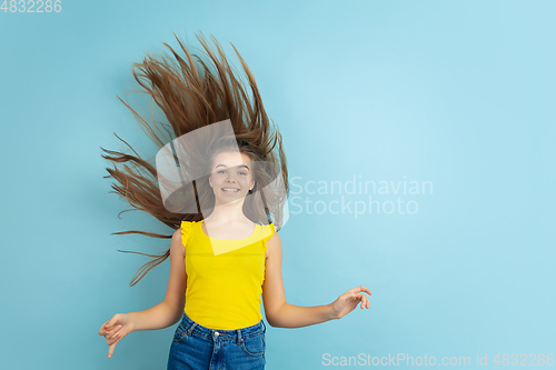 Image of Caucasian teen girl portrait isolated on blue studio background
