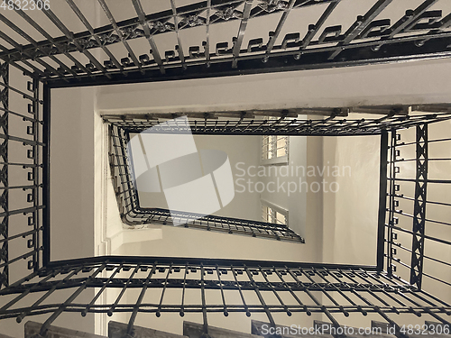 Image of Old rectangular spiraling winding staircase in an building