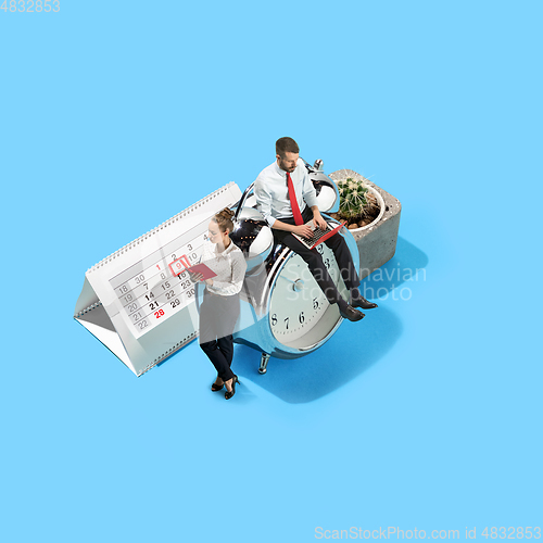 Image of High angle view of creative modern office on blue background - big things and little workers. Office working, daily task, typical problems and lifestyle concept. Collage.