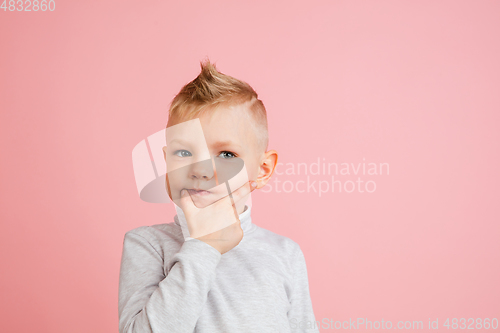 Image of Happy boy isolated on pink studio background. Looks happy, cheerful, sincere. Copyspace. Childhood, education, emotions concept