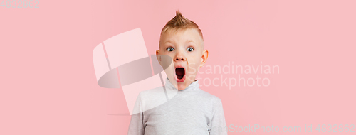 Image of Happy boy isolated on pink studio background. Looks happy, cheerful, sincere. Copyspace. Childhood, education, emotions concept