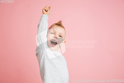 Image of Happy boy isolated on pink studio background. Looks happy, cheerful, sincere. Copyspace. Childhood, education, emotions concept