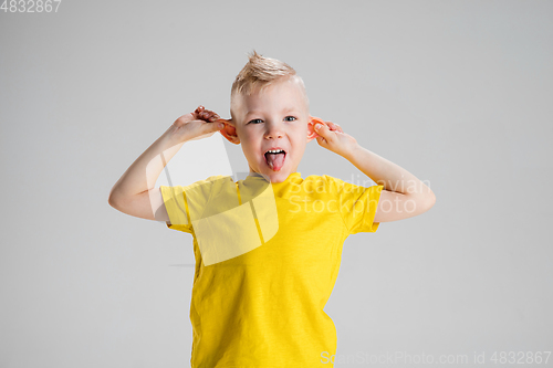 Image of Happy boy isolated on white studio background. Looks happy, cheerful, sincere. Copyspace. Childhood, education, emotions concept