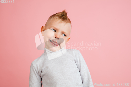 Image of Happy boy isolated on pink studio background. Looks happy, cheerful, sincere. Copyspace. Childhood, education, emotions concept