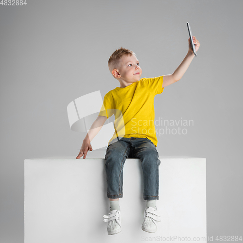 Image of Happy boy isolated on white studio background. Looks happy, cheerful, sincere. Copyspace. Childhood, education, emotions concept
