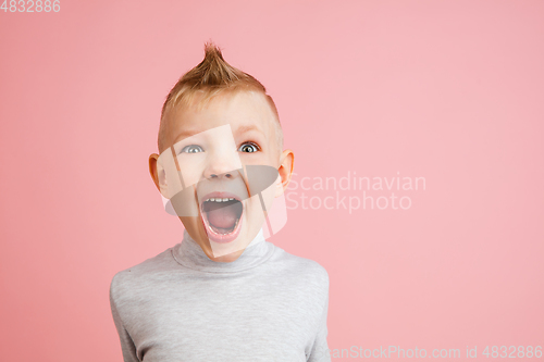 Image of Happy boy isolated on pink studio background. Looks happy, cheerful, sincere. Copyspace. Childhood, education, emotions concept