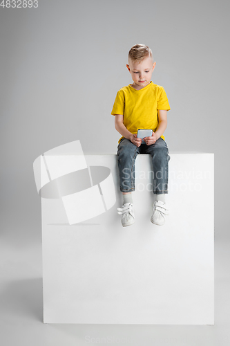 Image of Happy boy isolated on white studio background. Looks happy, cheerful, sincere. Copyspace. Childhood, education, emotions concept