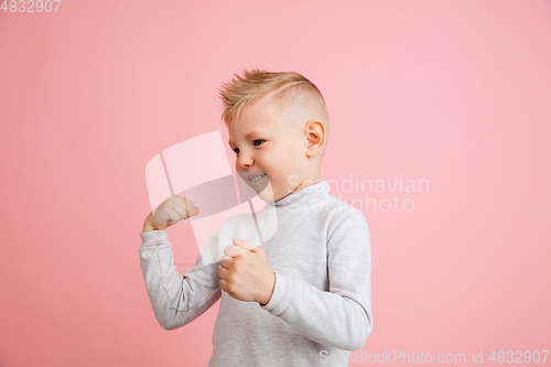 Image of Happy boy isolated on pink studio background. Looks happy, cheerful, sincere. Copyspace. Childhood, education, emotions concept