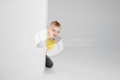 Image of Happy boy isolated on white studio background. Looks happy, cheerful, sincere. Copyspace. Childhood, education, emotions concept