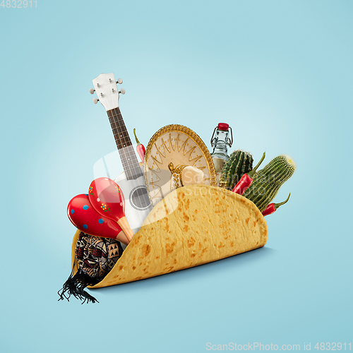 Image of Fresh and tasty taco filled with Sombrero, Ukulele, Maracas, cactus, drink on blue background.