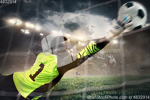 Image of African male soccer or football player, goalkeeper in action at stadium. Young man catching ball, training, protecting goals in motion.