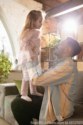 Image of Smiling. Happy father and little cute daughter at home. Family time, togehterness, parenting and happy childhood concept. Weekend with sincere emotions.