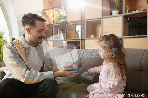 Image of Happy father and little cute daughter at home. Family time, togehterness, parenting and happy childhood concept. Weekend with sincere emotions.