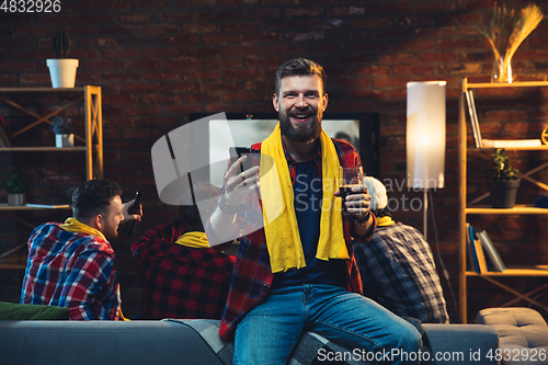 Image of Group of friends watching TV, sport match together. Emotional man cheering for favourite team, celebrating successful betting. Concept of friendship, leisure activity, emotions