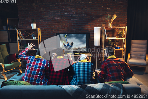 Image of Group of friends watching TV, sport match together. Emotional fans cheering for favourite team, watching on exciting game. Concept of friendship, leisure activity, emotions