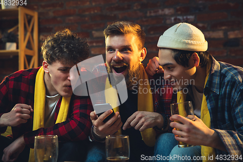 Image of Group of friends watching TV, sport match together. Emotional fans cheering for favourite team, watching on exciting game. Concept of friendship, leisure activity, emotions