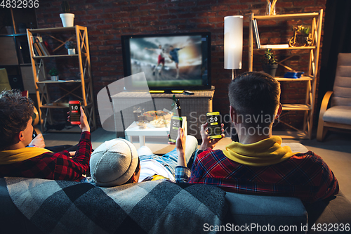 Image of Group of friends watching TV, sport match together. Emotional fans cheering for favourite team, watching on exciting game. Concept of friendship, leisure activity, emotions