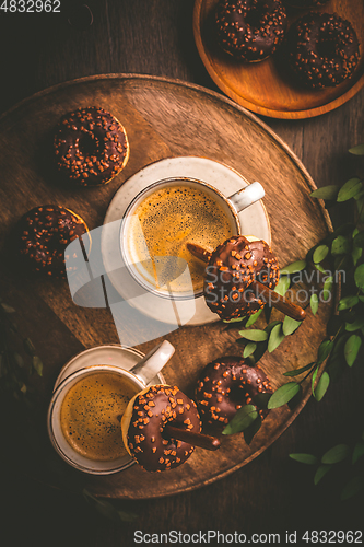 Image of Two cups of Caffe Americano with small chocolate donuts