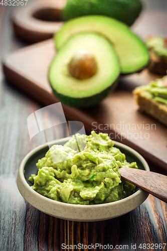 Image of Guacamole dip or spread on wooden kitchen table