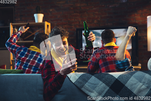 Image of Group of friends watching TV, sport match together. Emotional man cheering for favourite team, celebrating successful betting. Concept of friendship, leisure activity, emotions