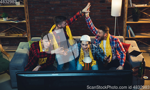 Image of Group of friends watching TV, sport match together. Emotional fans cheering for favourite team, watching on exciting game. Concept of friendship, leisure activity, emotions